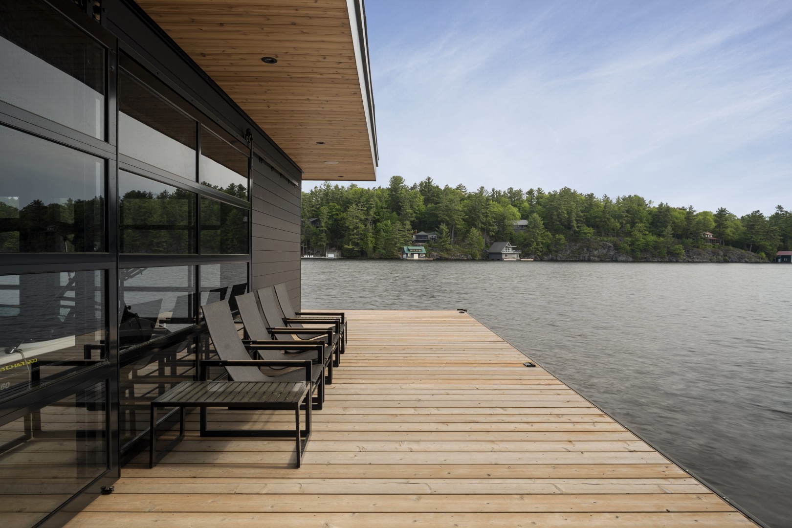 Cameron Bay boathouse dock with a cedar soffit over the lake — built work by Corbin Patten Designs